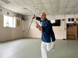 Janick Poupée présentant un sabre dans le dojo du Budokai Brive